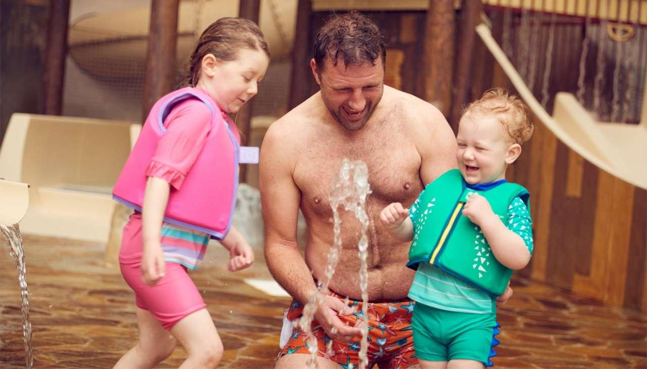 A father with his children in the play area in The Subtropical Swimming Paradise.