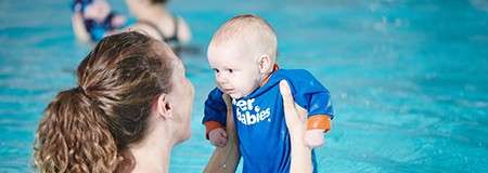 Woman holding a baby in the pool