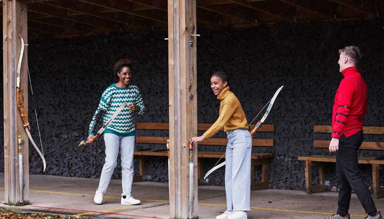 Two teenage girls laughing and enjoying Target Archery.