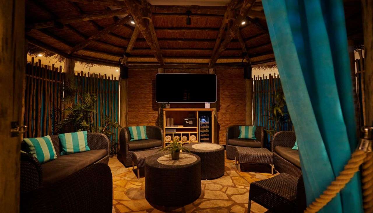 Inside the Cabana Cove with a mounted TV, comfortable seating and other luxuries.