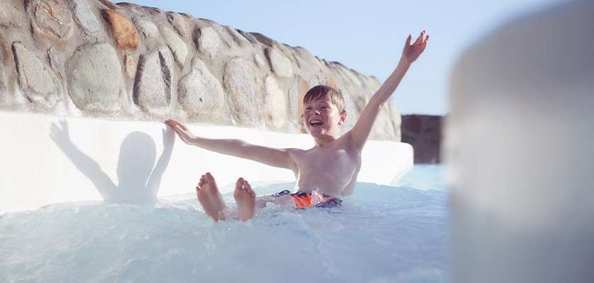 A boy sliding down the rapids of the Subtropical Swimming Paradise