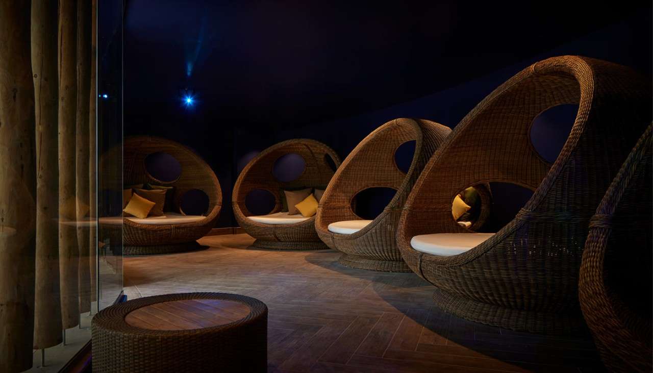 Comfortable egg chairs in a room with dim lighting.