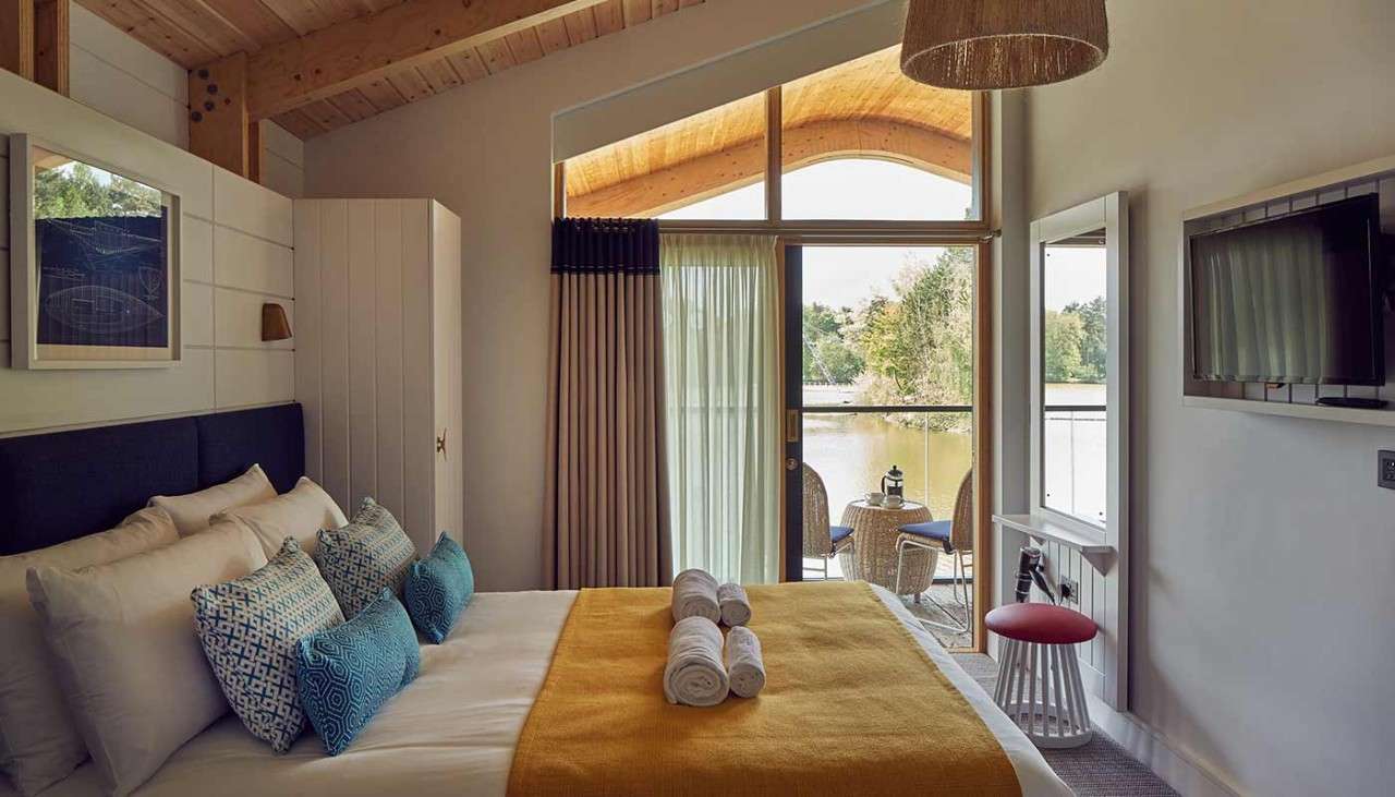 A bedroom and balcony area inside a Waterside Lodge. 