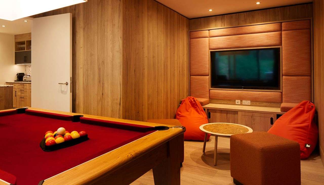 Games room with pool table, bean bags and TV.