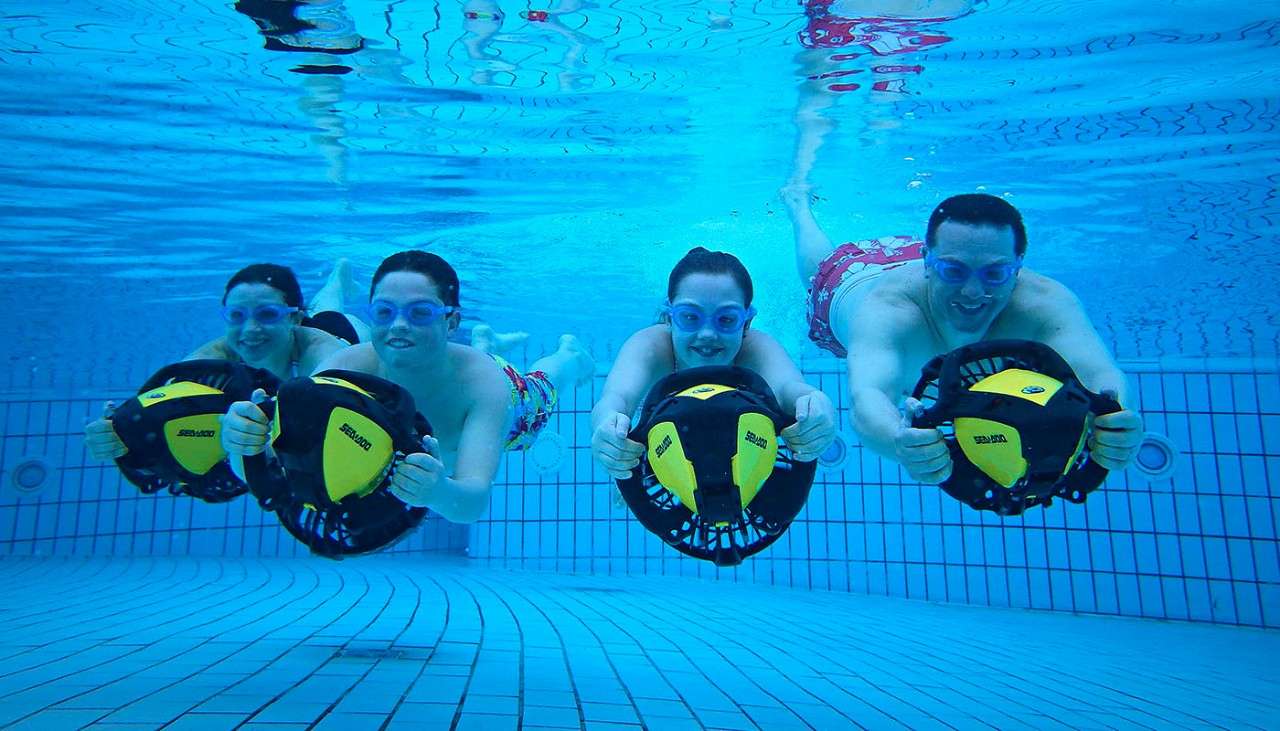 A family of four using aqua jets underwater