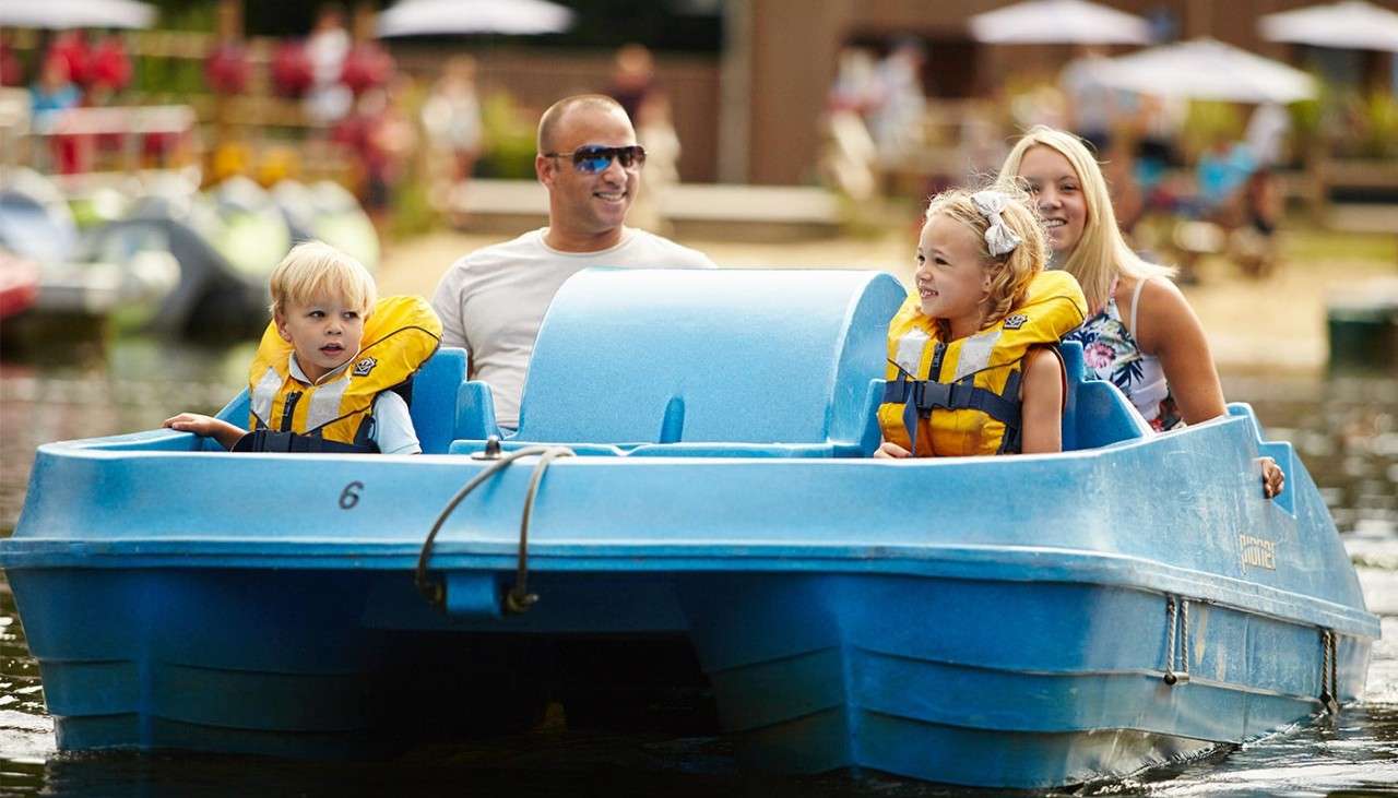 Family sitting in a Pedalo on the lake