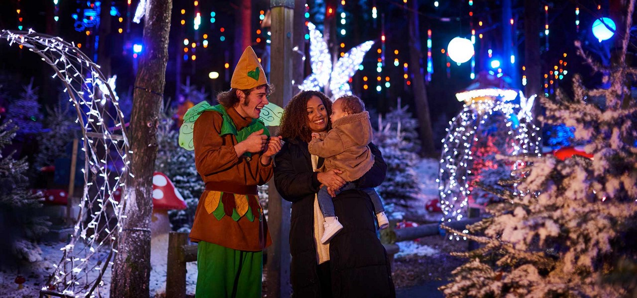 A family in the forest surrounded by fairy lights