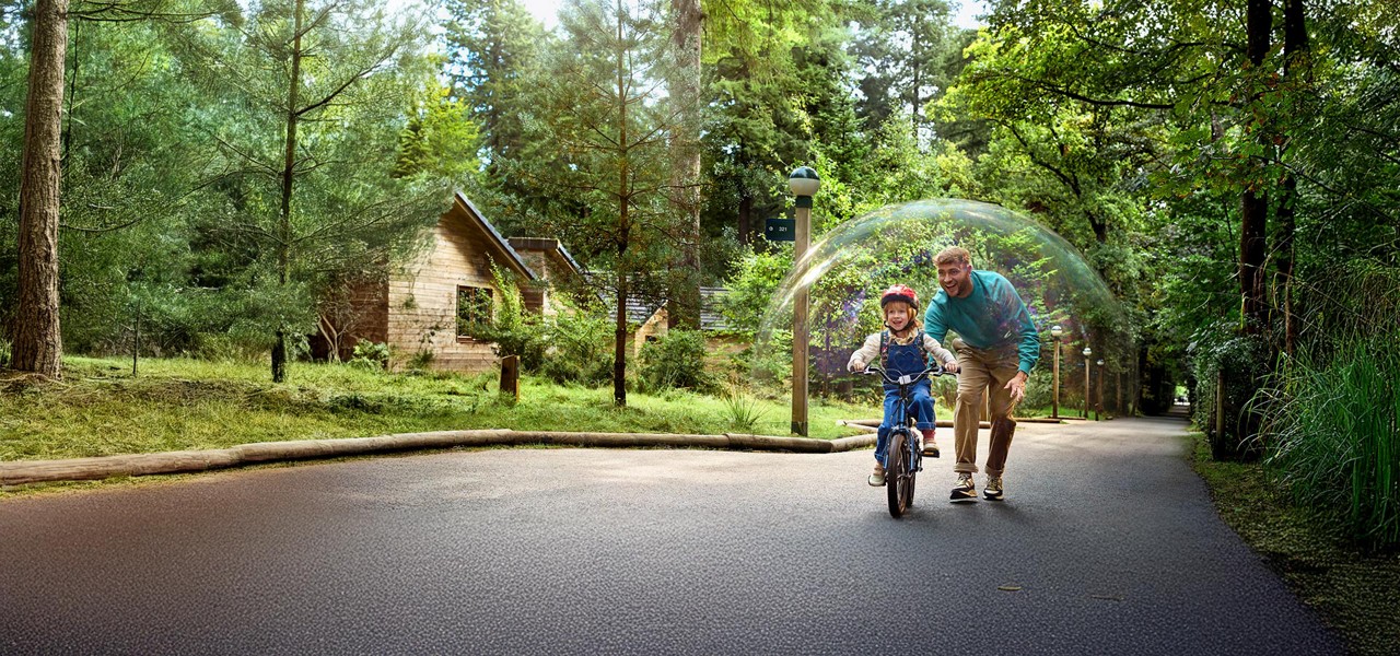 A father helping his child to ride a bike.