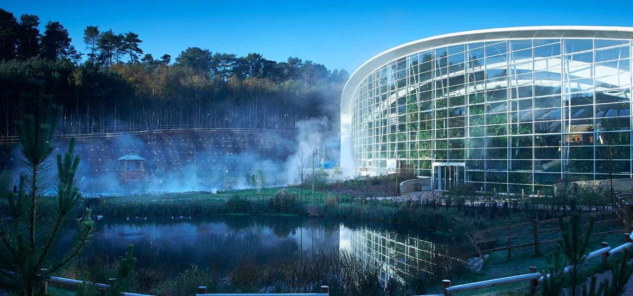 Exterior of the Woburn Forest Subtropical Swimming Paradise, with steam rising from the outside pool.