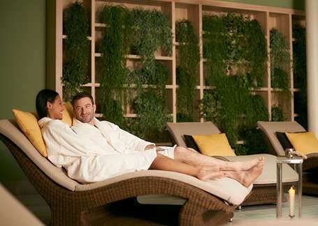 A couple laid on sun beds in their robes.