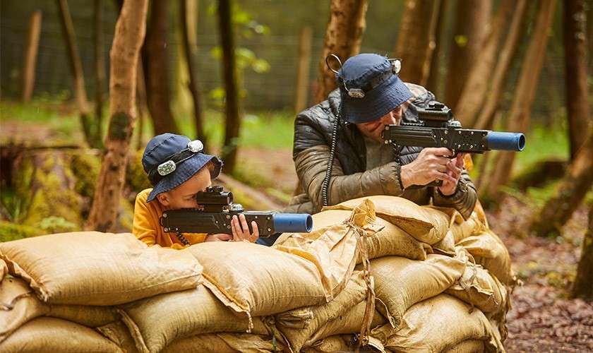 A father and son playing laser combat together.