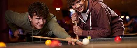 Two teenage boys playing pool