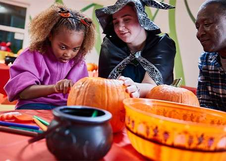 A child carving a pumpkin.