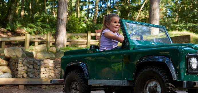 A little girl driving a truck on the off road explorers.