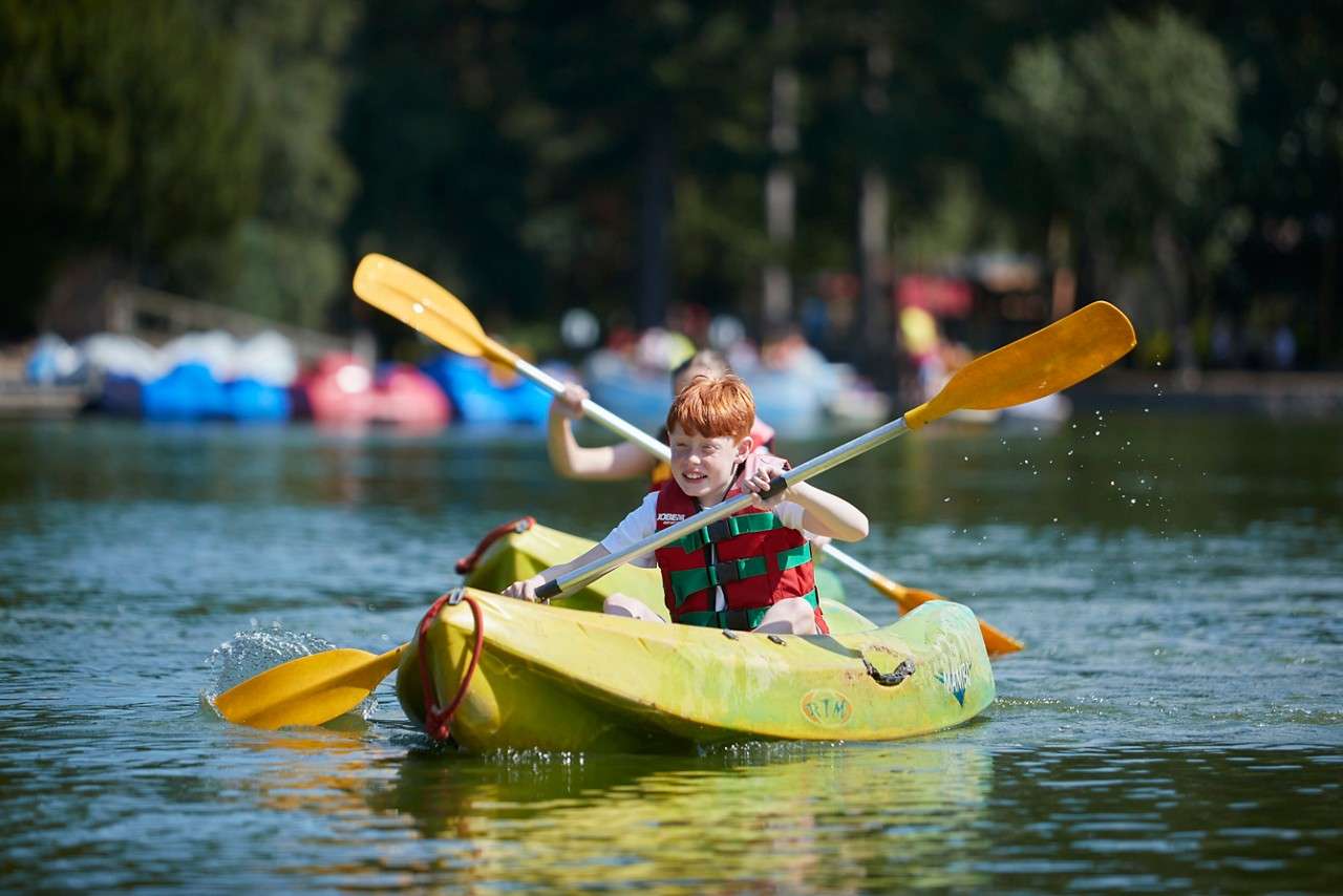 Children kayaking on the lake in the summer.