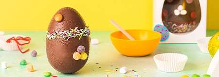 Chocolate Easter egg decorated with sprinkles and sweets