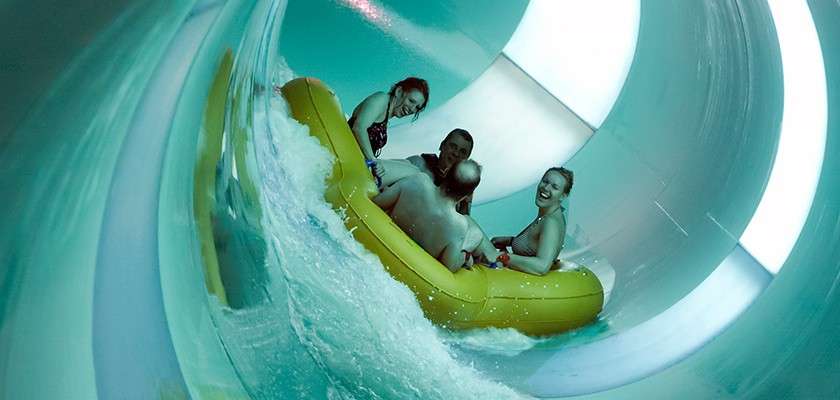 A family on the tropical cyclone slide in the Subtropical Swimming Paradise.