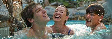 A mother with her teenage sons laughing in the Lazy River.