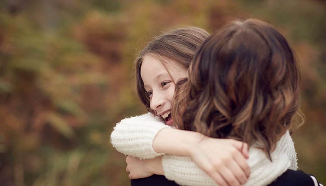 Mother and daughter hugging.