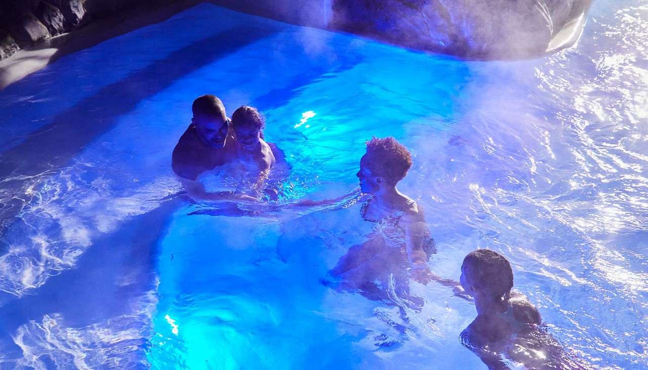A family swimming outside in the Subtropical Swimming Paradise.