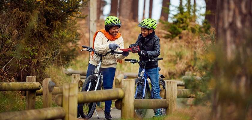 A mum and her son on an autumn bike ride through the forest.