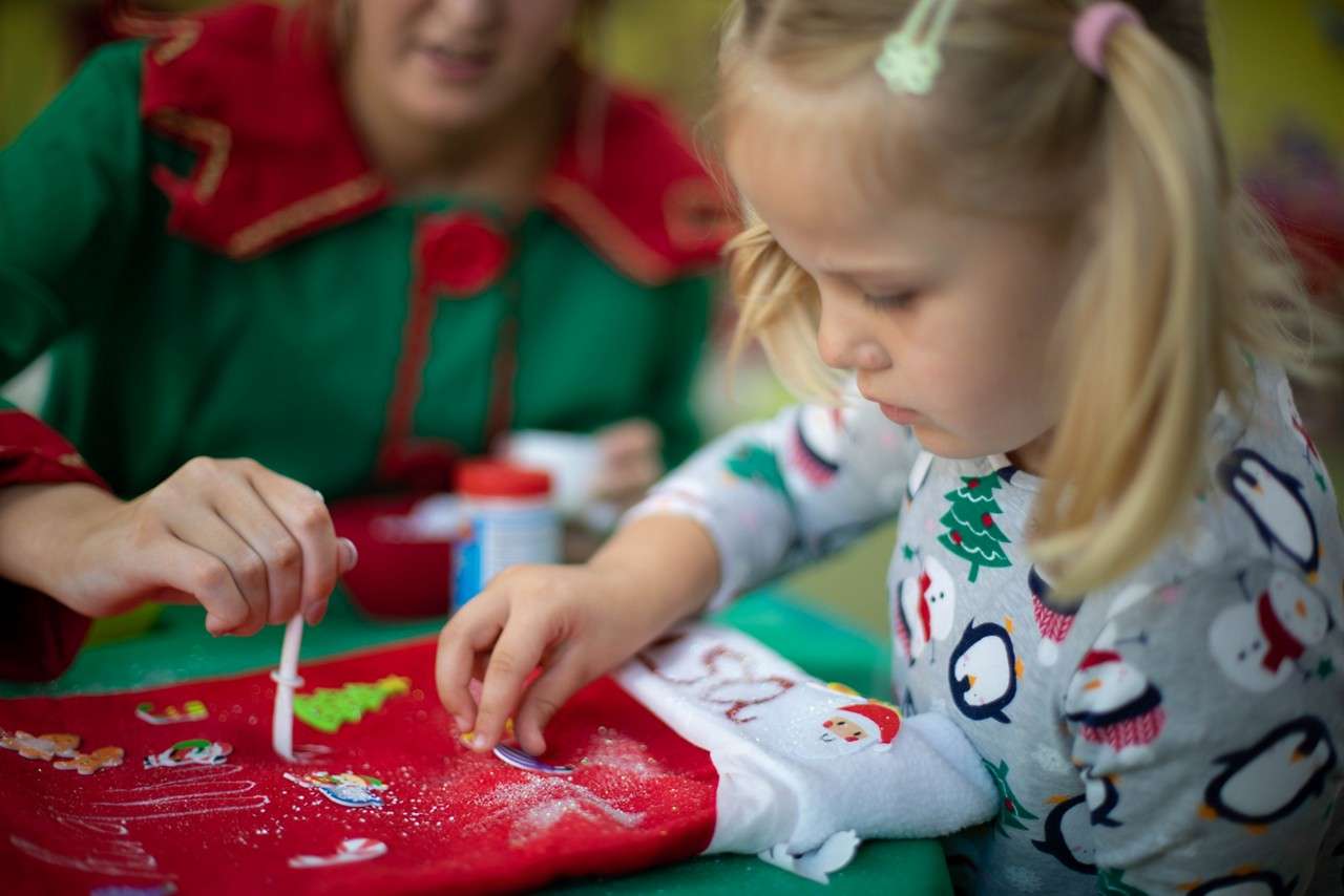 Young girl decorating a Santa Sack.