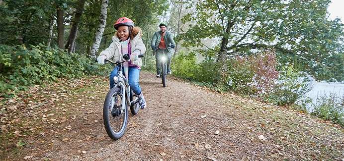 A girl riding on a bike through the forest