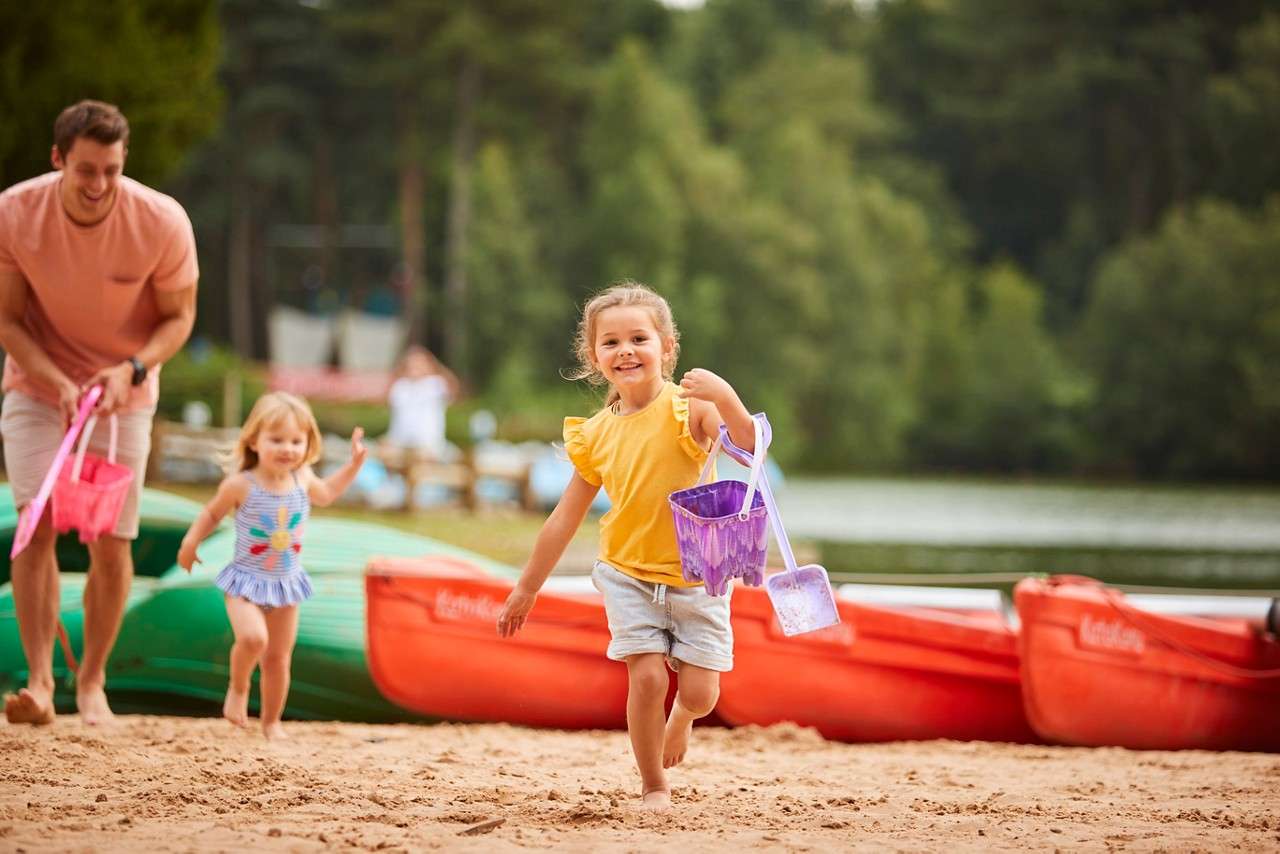 A family looking up at the lights in the forest.