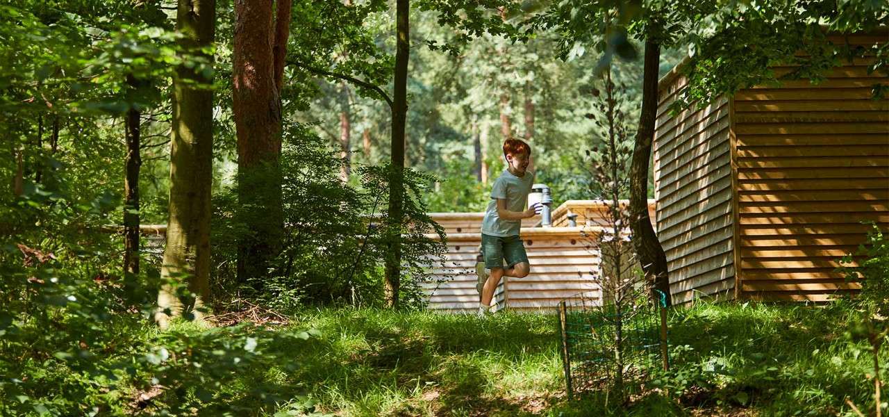 A boy running through the forest.