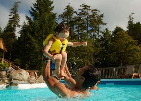 A father and his young child playing in the pool