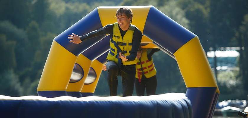 Teenage boy running along the inflatable Aqua Parc obstacle course 