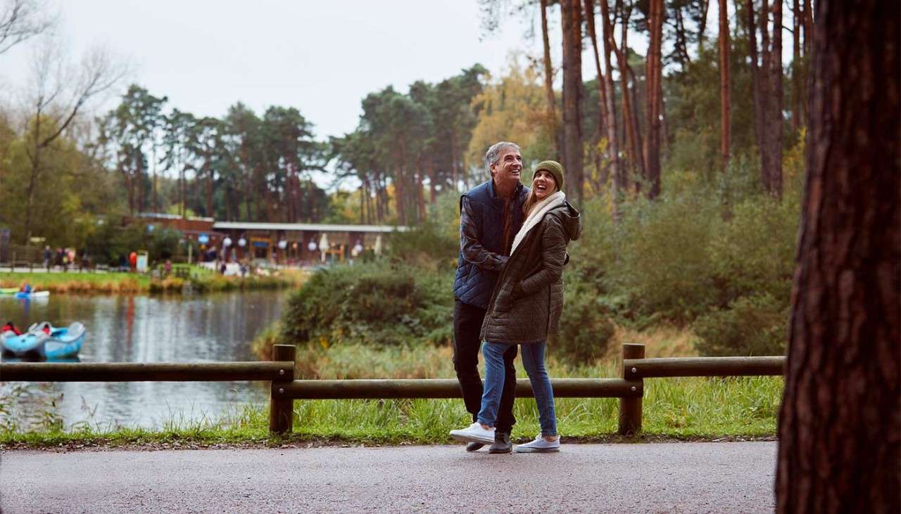 A man and woman walking next to the lake.