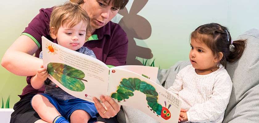 Two young children in the creche reading a story