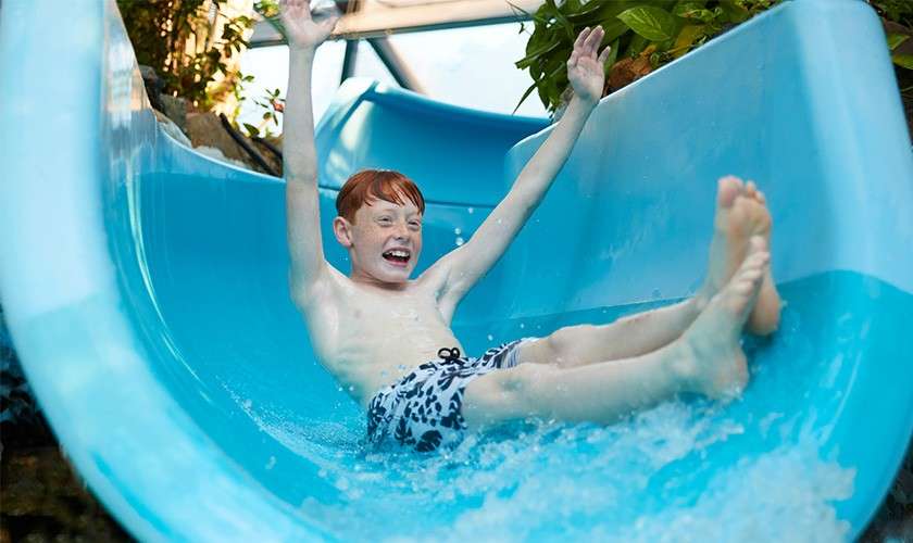 A father playing with his son wearing an inflatable pool ring in the Subtropical Swimming Paradise..