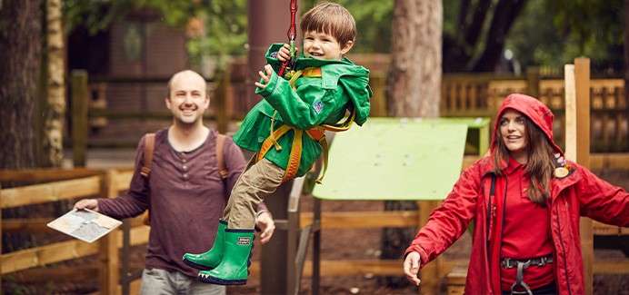 A child wearing a harness completing the mini trek obstacle course.