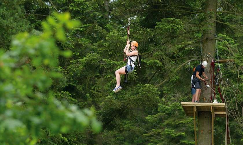 A girl on a zip wire on the Ariel Adventure.