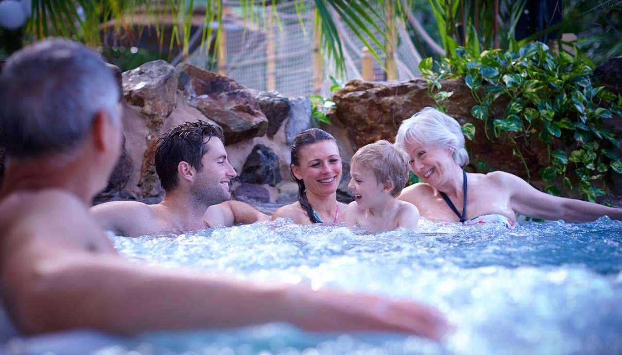 Extended family relaxing in a jacuzzi in the Subtropical Swimming Paradise 