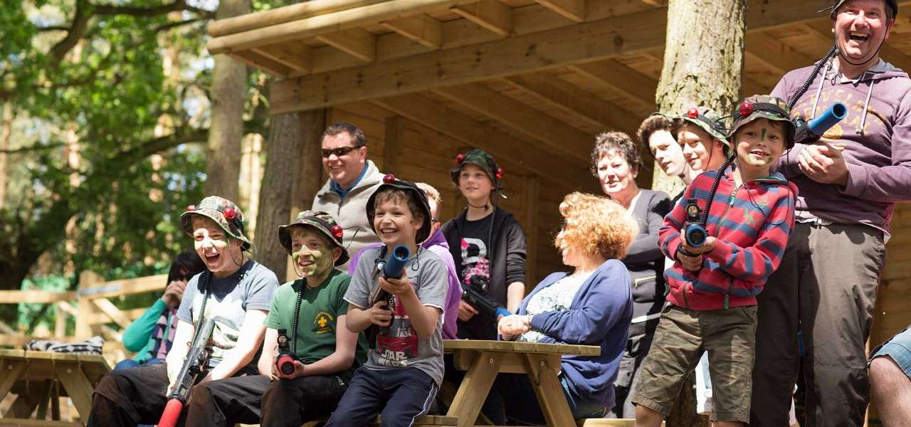 Several children and adults get ready to play on the Laser Combat course