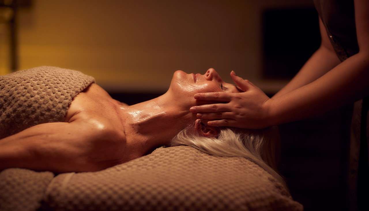 A woman recieving a face massage as part of a facial