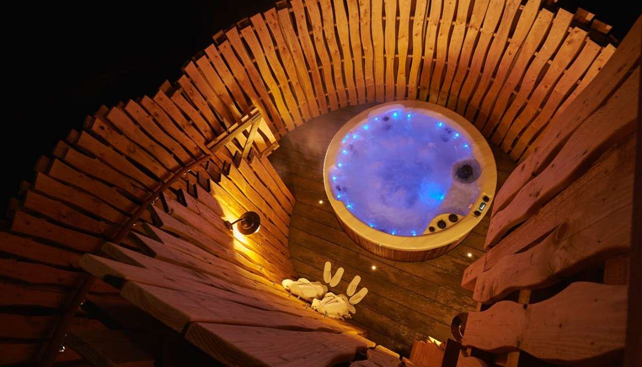 An outdoor hot tub at night time 