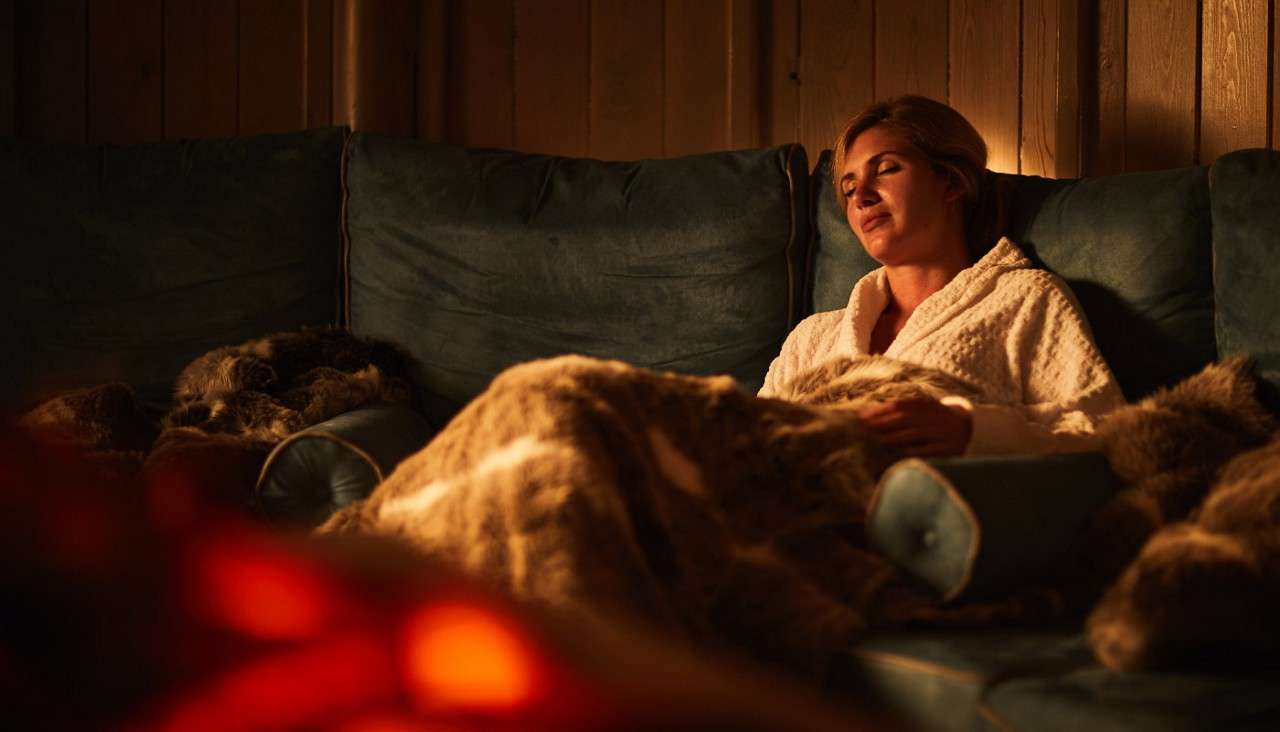 Woman snuggled up in the Scandinavian Snug inside the Aqua Sana Spa