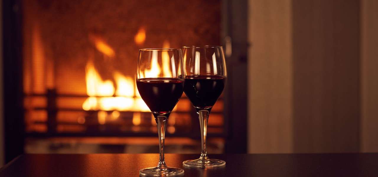 Two glasses of red wine in front of an open fire in a Center Parcs lodge