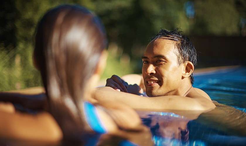 Couple relaxing in an outdoor pool at Aqua Sana Spa.