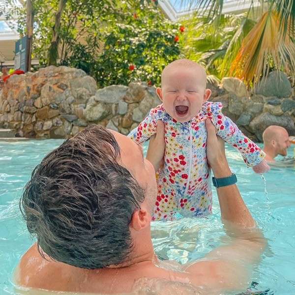 A dad holding his baby out of the pool in the Subtropical Swimming Paradise