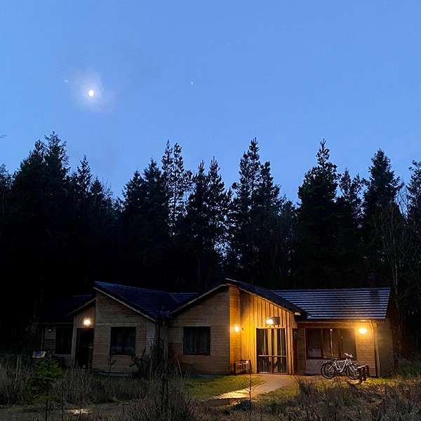 A lodge in the forest at night-time 