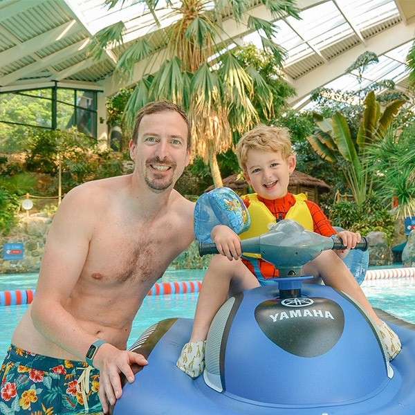 A dad and his young son on a water jet ski