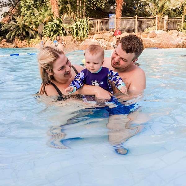 Mum and dad in the Subtropical Swimming Paradise with their young child