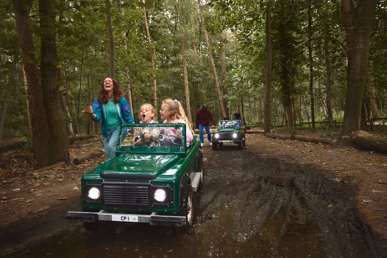 Young girls driving an Off Road Explorer through the woods.