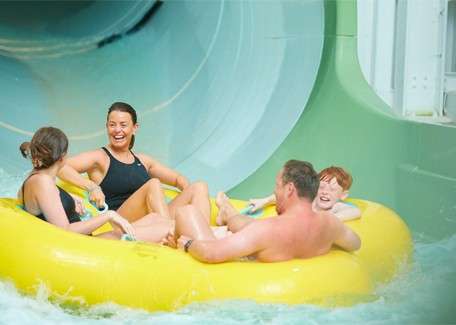 Family going down a waterslide in a large inflatable.