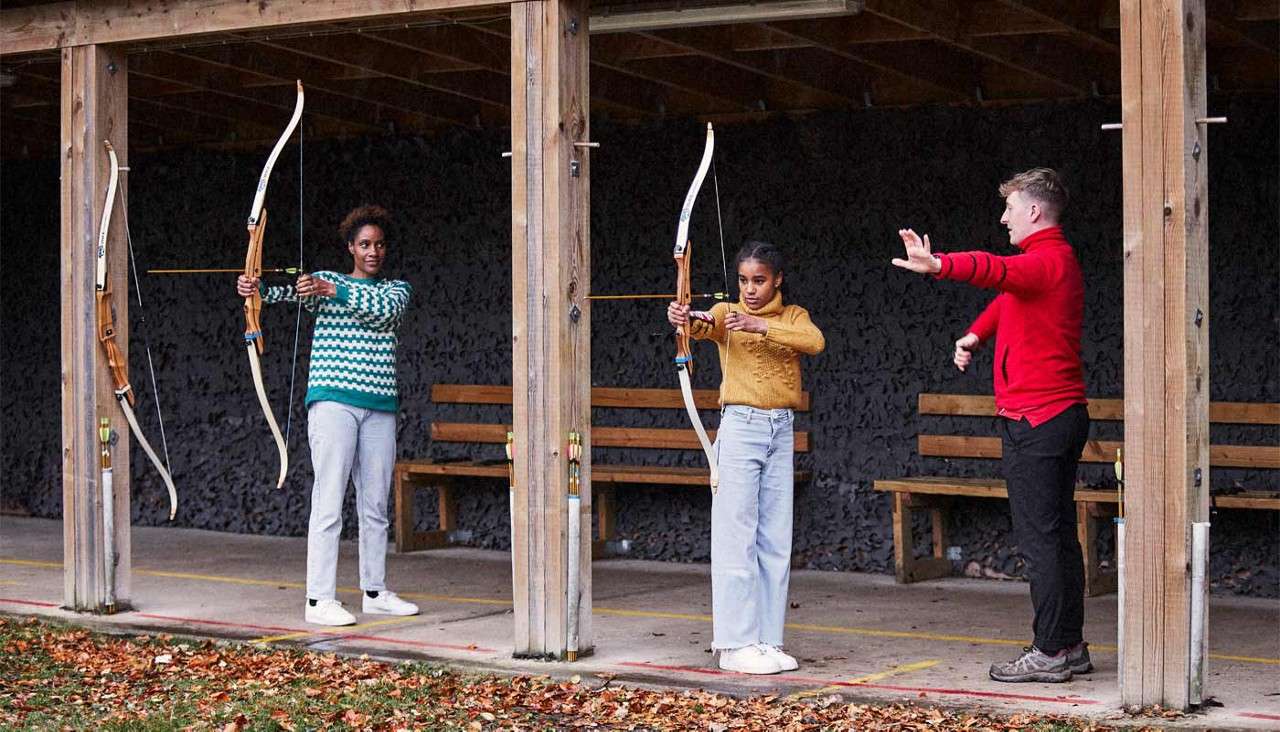 Two ladies aiming bow and arrows.